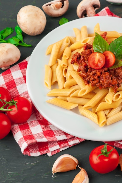 Pasta met vlees, tomatensaus en groenten op tafel