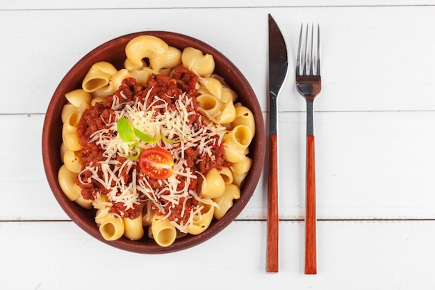 Pasta met vlees, tomatensaus en groenten op tafel