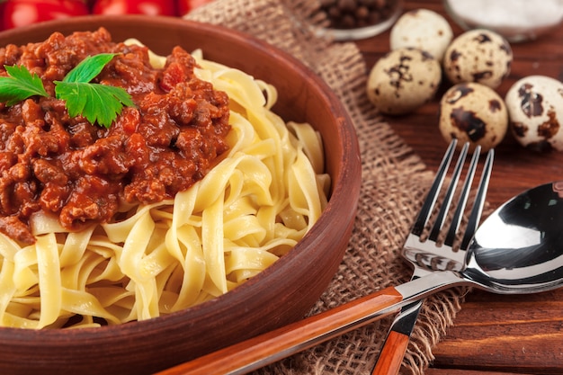 Pasta met vlees, tomatensaus en groenten op tafel