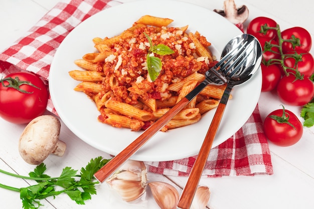 Pasta met vlees, tomatensaus en groenten op tafel