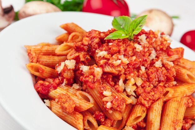 Pasta met vlees, tomatensaus en groenten op tafel