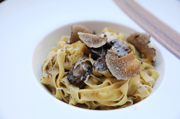 Pasta met zwarte truffels op houten achtergrond, Italiaans eten