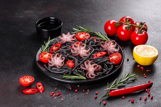 Pasta met zwarte zeevruchten met garnalen, octopus en mosselen. Mediterrane gastronomische gerechten. Zwarte pasta met octopus op een zwarte stenen plaat