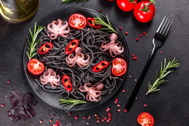 Pasta met zwarte zeevruchten met garnalen, octopus en mosselen. Mediterrane gastronomische gerechten. Zwarte pasta met octopus op een zwarte stenen plaat