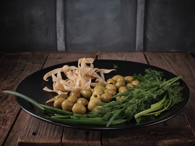 Pasta, olives, green onions and dill on a plate