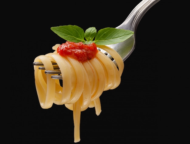 Pasta op de vork met saus en basilicum