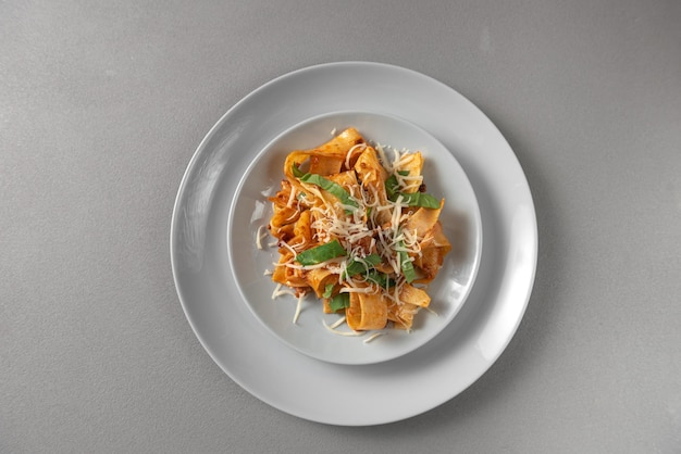 Pasta pappardelle with beef ragout sauce in grey bowl grey background