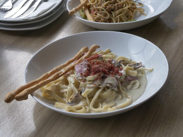 Photo pasta penne bolognese on a white plate on the table