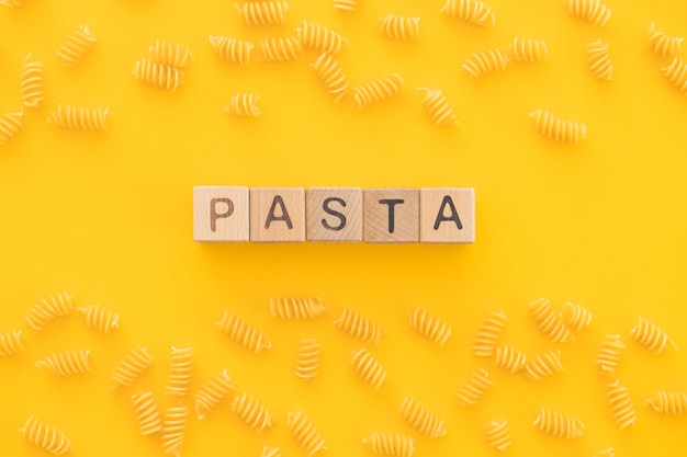 Pasta penne isolated on yellow from above