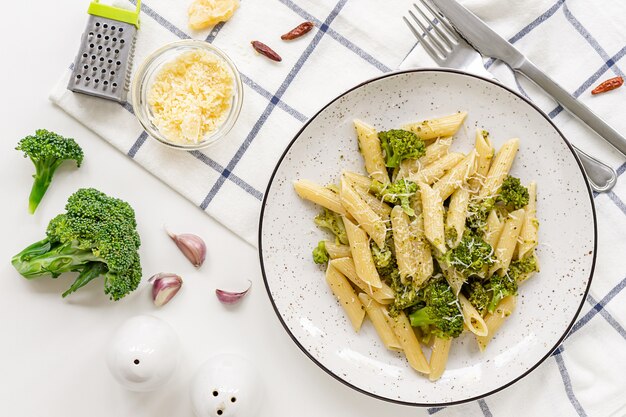 Pasta penne met broccoli en Parmezaanse kaas op witte tafel.