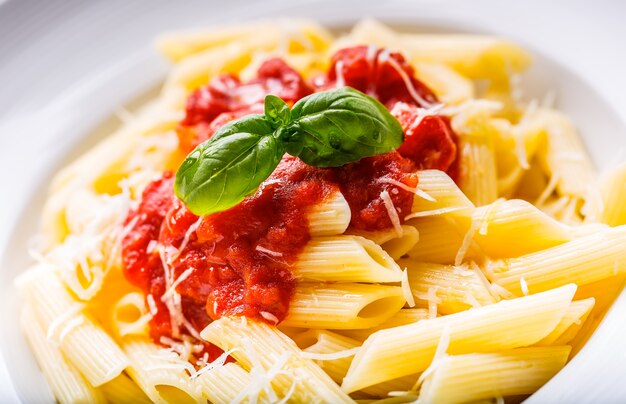 Pasta Penne met Tomaten Bolognesesaus, Parmezaanse Kaas en Basilicum. Mediterrane gerechten. Italiaanse keuken.