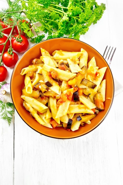 Pasta penne with eggplant and tomatoes on board top