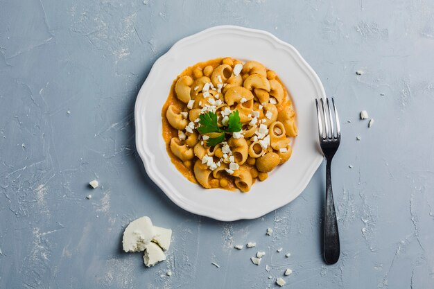 Pasta Pipa the rigat with a sauce of chickpeas and tomatoes, sprinkled with feta cheese and cilantro 