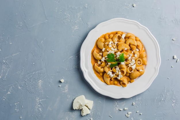 Pasta Pipa the rigat with a sauce of chickpeas and tomatoes, sprinkled with feta cheese and cilantro 