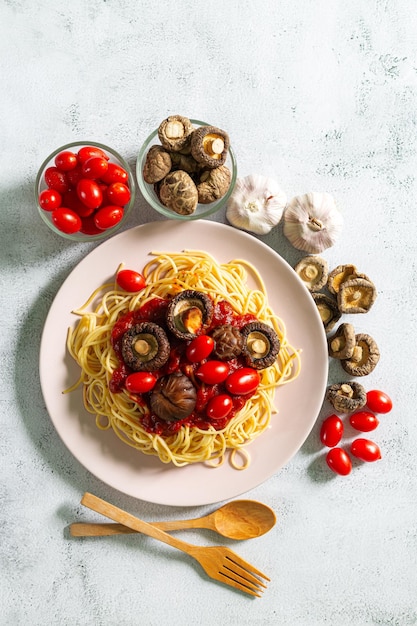 Foto pasta su un piatto, deliziosa pasta servita con salsa di pomodoro, pomodori freschi, basilico e formaggio