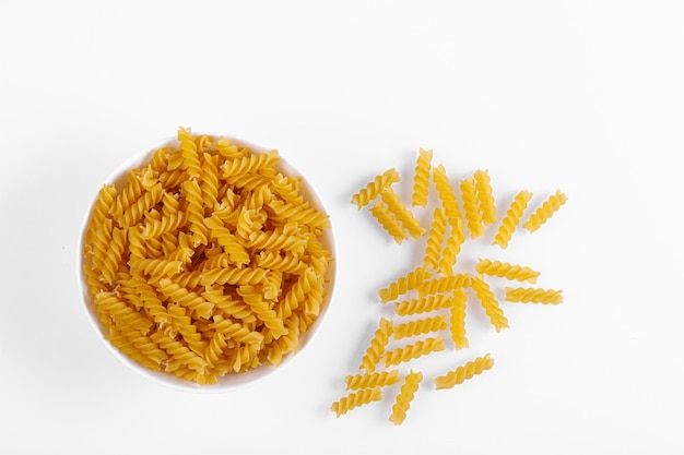 Pasta products in the form of a spiral on a plate texture on a white background