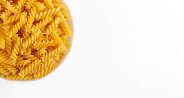 Pasta products in the form of a spiral on a plate texture on a white background