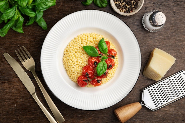 Pasta ptitim israeli couscous in a white plate top view