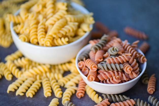 Pasta rauwe macaroni op witte kom achtergrond close-up rauwe macaroni spiraal pasta ongekookt heerlijke volkoren fusilli pasta voor het koken van voedsel