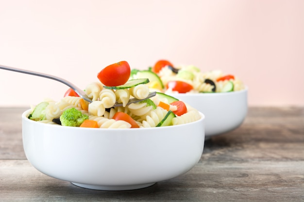Pasta salad in a bowl on a rustic wooden table
