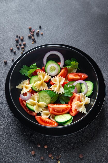 Pasta salad no meat tomato cucumber farfalle healthy meal diet snack on the table copy space