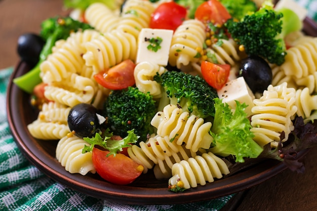 Pasta salad with tomato, broccoli, black olives, and cheese feta