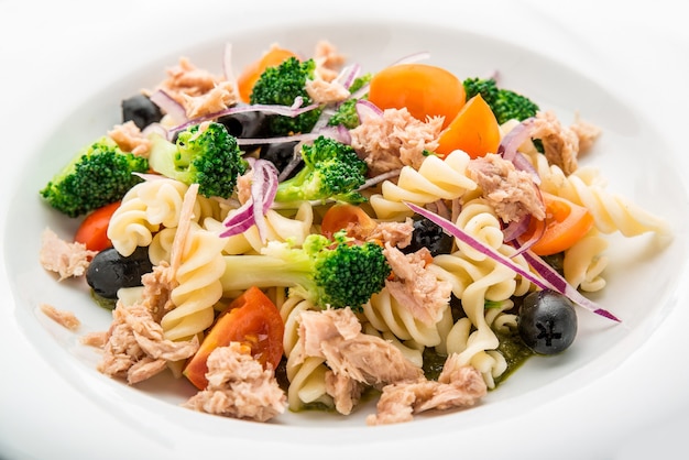 Pasta salad with tuna, olives and cherry tomatoes on the plate