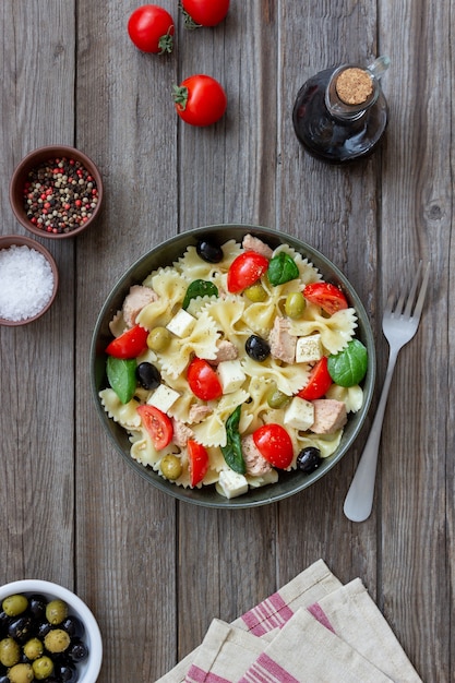 Pasta salad with tuna, tomatoes and white cheese. farfalle.\
healthy eating. diet.