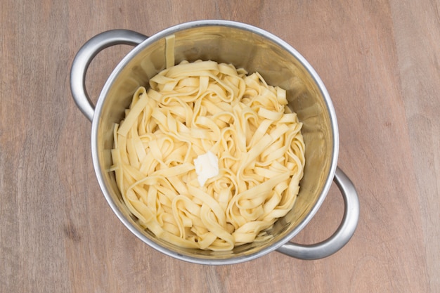 Pasta in a saucepan on brown background