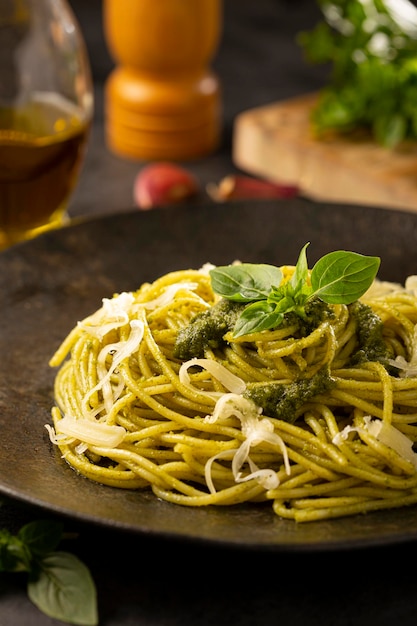 Pasta spaghetti met pestosaus en basilicumblad.