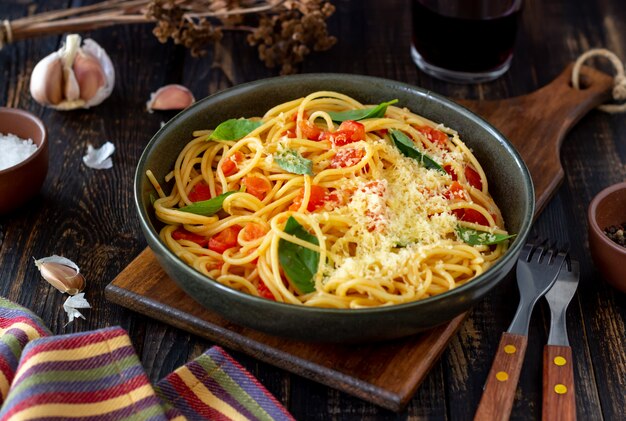 Pasta spaghetti met tomaten, basilicum en Parmezaanse kaas. Italiaanse keuken. Recept. Gezond eten.