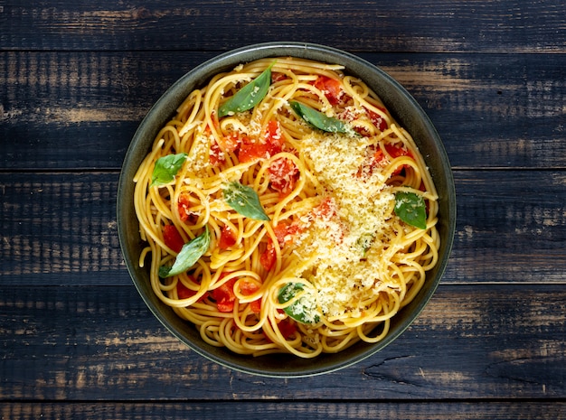 Pasta spaghetti met tomaten, basilicum en Parmezaanse kaas. Italiaanse keuken. Recept. Gezond eten.