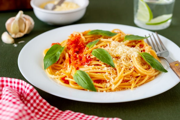 Pasta spaghetti met tomaten, basilicum en Parmezaanse kaas. Italiaanse keuken. Recept. Gezond eten.