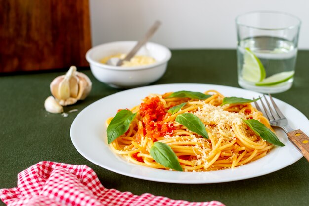 Pasta spaghetti met tomaten, basilicum en Parmezaanse kaas. Italiaanse keuken. Recept. Gezond eten.