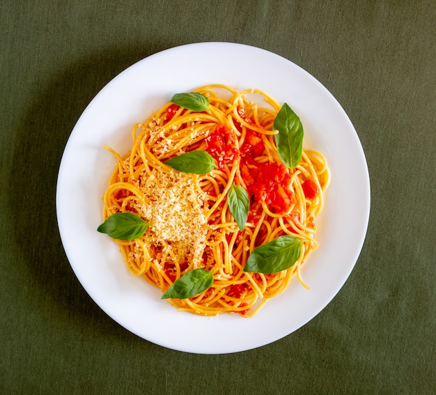 Pasta spaghetti met tomaten, basilicum en Parmezaanse kaas. Italiaanse keuken. Recept. Gezond eten.