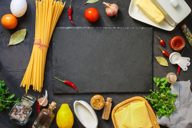 pasta, spaghetti of bucatini en tomatensaus ingrediënten. voedsel achtergrond. kopie ruimte