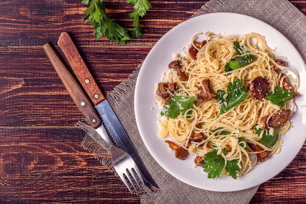 Pasta spaghetti with chanterelles mushrooms on wooden.