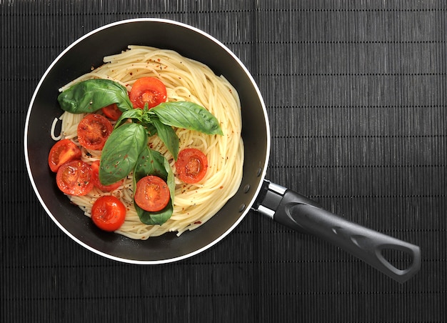 Pasta spaghetti with cherry tomatoes and basilikum in the pan