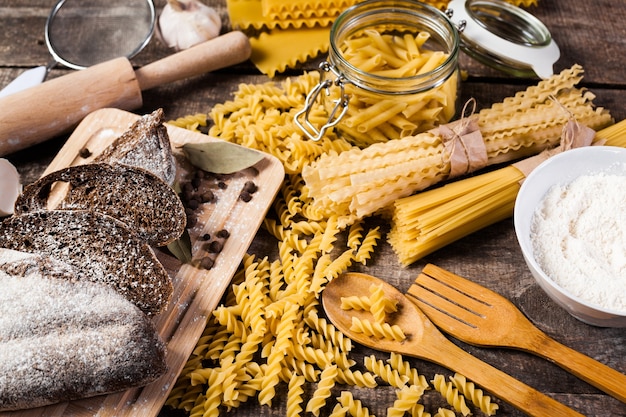 pasta spaghetti with flour, egg on old wooden background