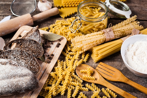 Pasta spaghetti with flour, egg on old wooden background