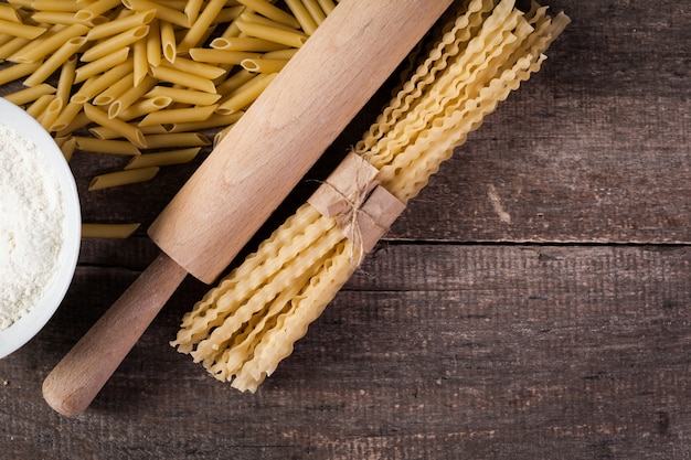 Pasta spaghetti with flour, egg on old wooden