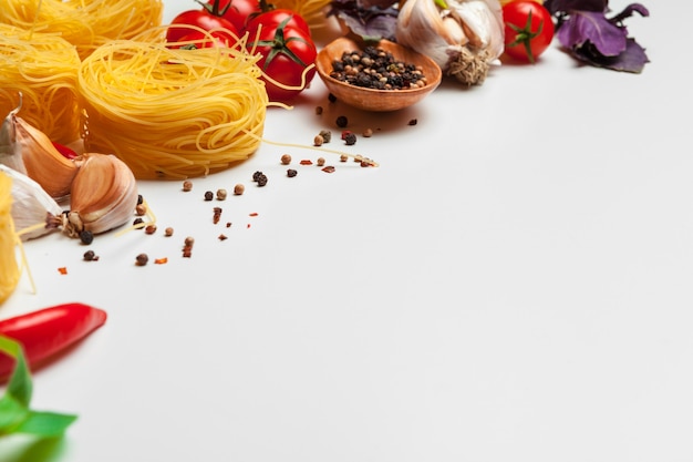 Pasta Spaghetti with ingredients for cooking pasta on a white background, top view.