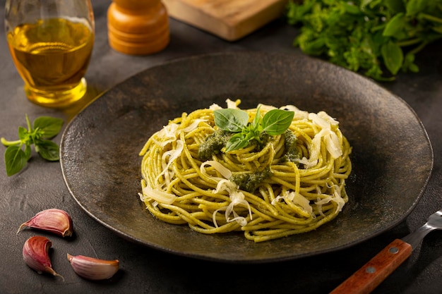 Pasta spaghetti with pesto sauce and basil leaf.