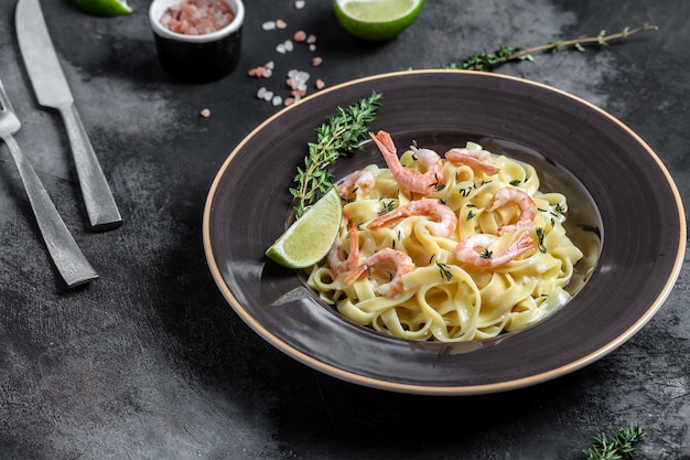 Premium Photo | Pasta spaghetti with shrimps, bechamel sauce, thyme and  lime, fettuccine pasta, italian cuisine, food recipe background. close up.