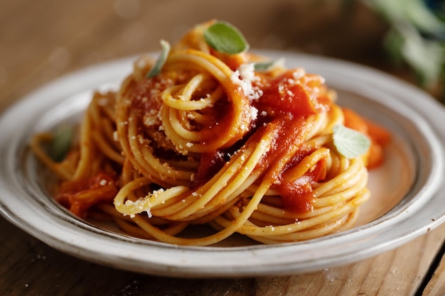 Pasta spaghetti with tomato sauce and cheese served on plate.