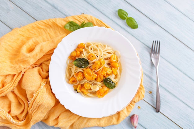 Pasta, spaghetti with yellow tomato in white plate