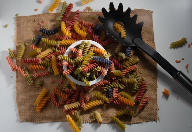 Photo pasta spread on a table next to utensils