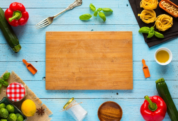 Pasta tagliatelle with pesto sauce and other vegetables on a wood table