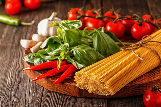 pasta, tomaten, knoflook, peper en basilicum op de oude houten.