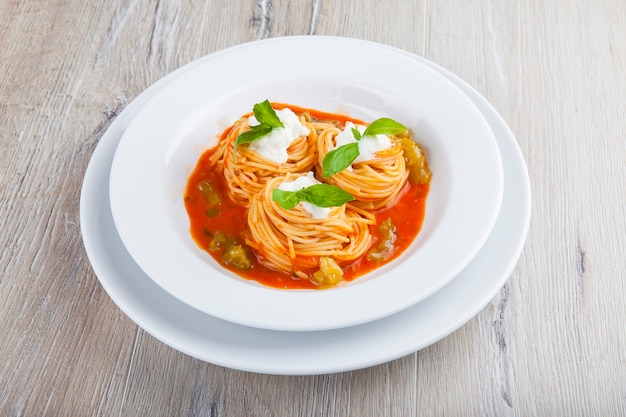 pasta in tomato sauce with curd sauce and basil